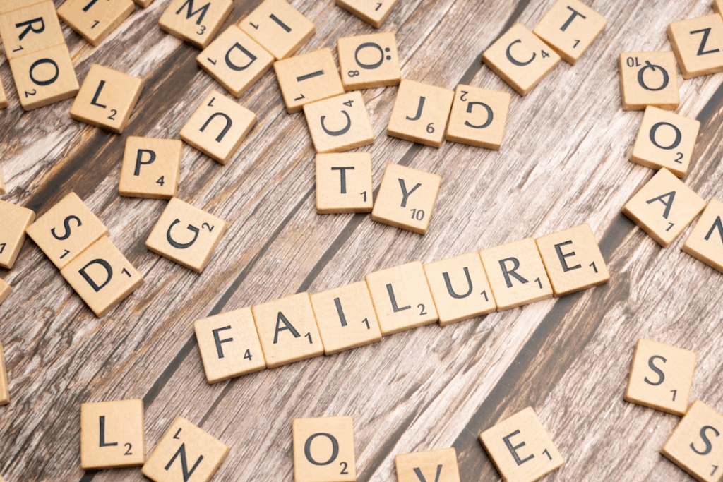 Wooden letter tiles spelling “FAILURE”, symbolizing reframing mistakes into learning.