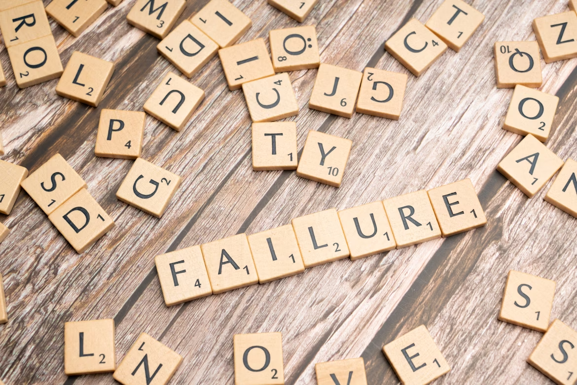 Wooden letter tiles spelling “FAILURE”, symbolizing reframing mistakes into learning.
