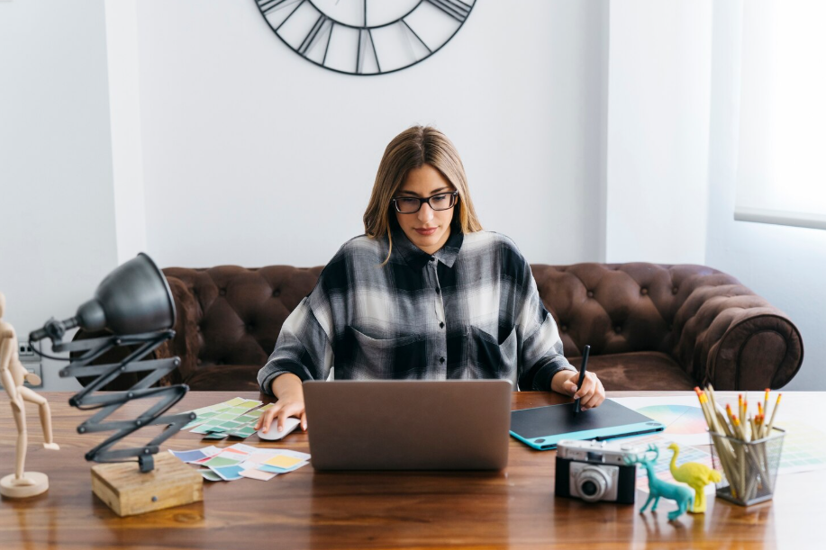 Freelancer managing a portfolio career on a laptop with design tools and a camera