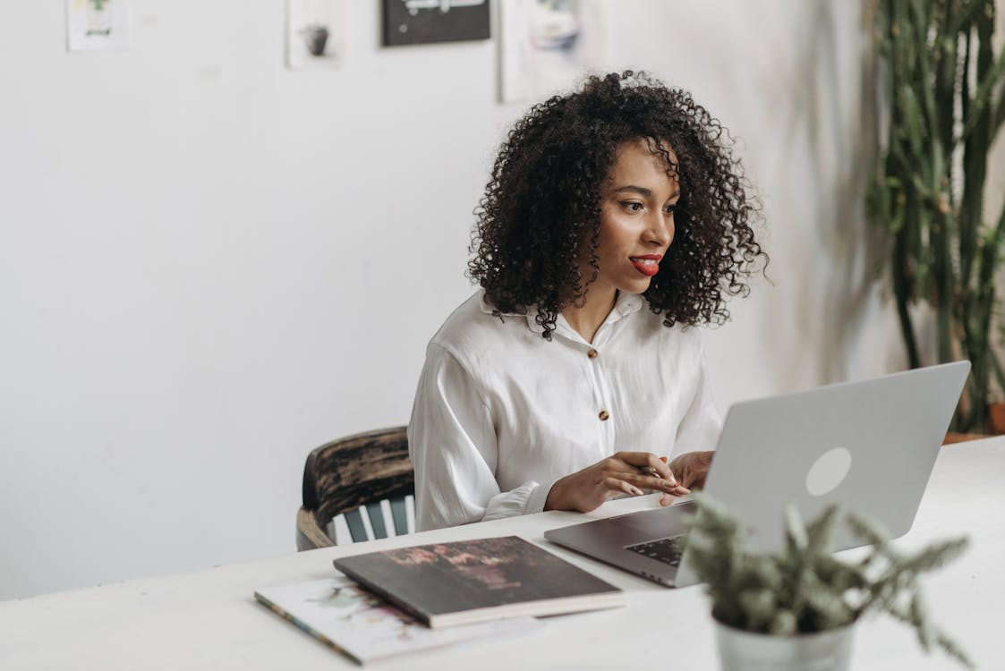 Woman working on a laptop, illustrating skill-building side hustles.